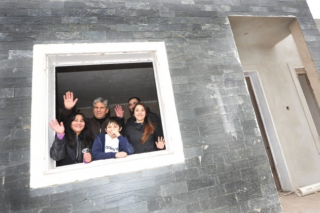 El Gobernador junto a la preadjudicataria Nelly del Carmen Lucero y sus hijos, saludan por la ventana de su futuro hogar