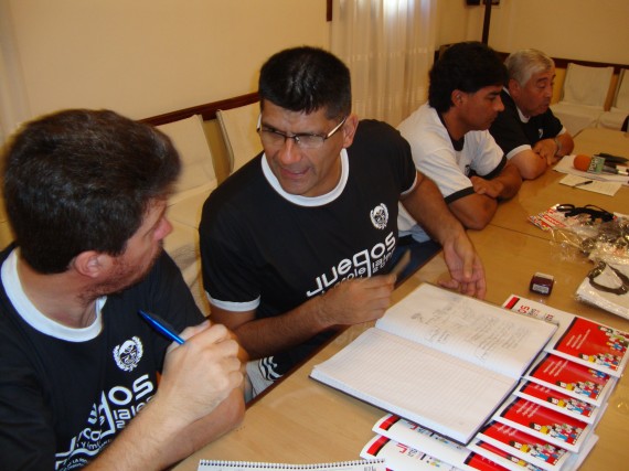 El jefe del Programa Deporte Estudiantil, Silvio Leyría (centro), al momento de rubricar el contrato