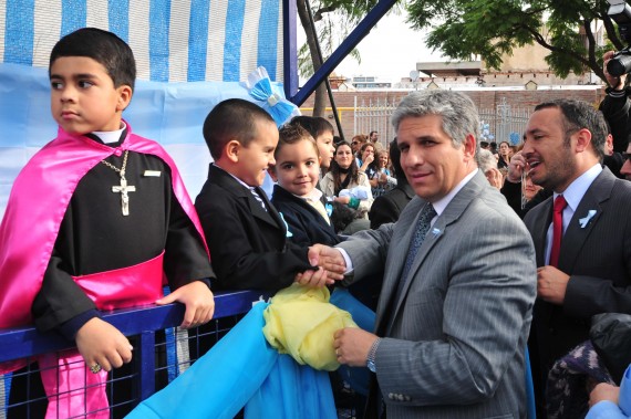 El gobernador, CPN Claudio Poggi,  saludando al niño que actuó de gobernador en el acto.