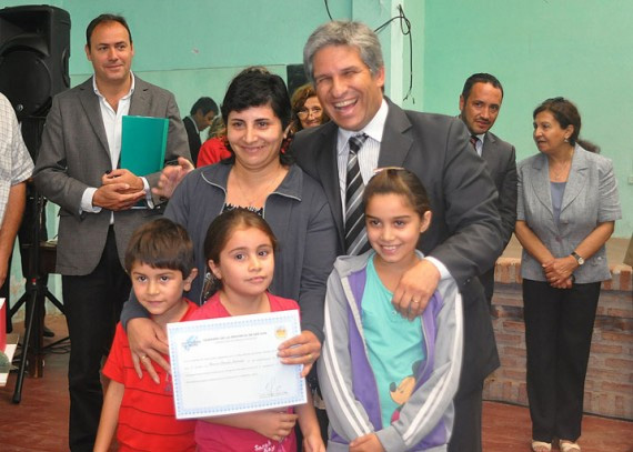 Familia feliz: El gobernador durante la entrega de un certificado de preadjudicación a una familia de la localidad de Juan Jorba.