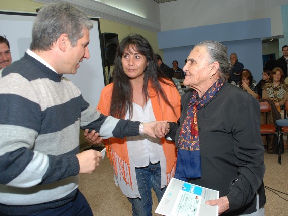 El gobernador de la Provincia, CPN. Claudio Poggi junto con Tuca Videla de 94 años, quien recibió de sus manos el aporte económico.