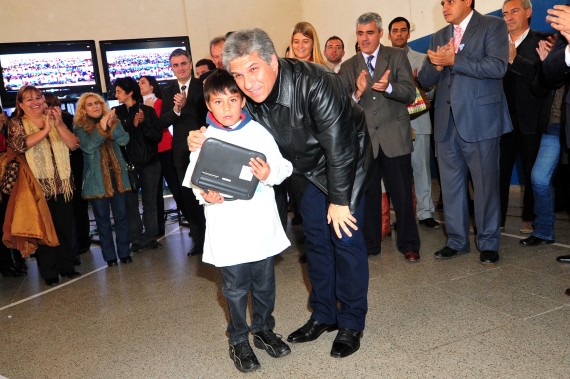 El gobernador de la Provincia, CPN. Claudio Poggi, junto a uno de los chicos beneficiados de la entrega de computadoras.