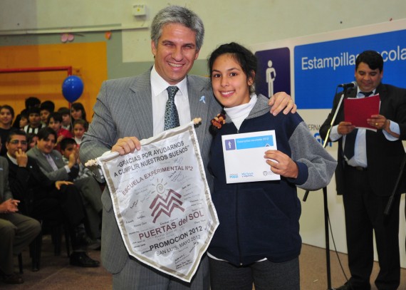 El gobernador de San Luis, junto a una alumna de la escuela Puertas del Sol, en la entrega de estampillas escolares.