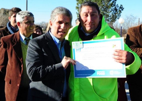 Claudio Poggi entregando uno de los certificados a un trabajador forestal.