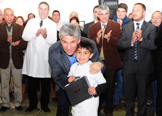 El Gobernador haciendo entrega de una computadora.