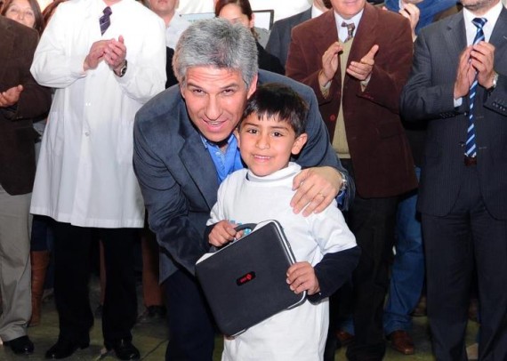 Poggi junto a un chico del Departamento Pedernera que recibió su esperada computadora