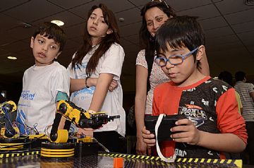 Los chicos se apasionan con los robots en la feria.