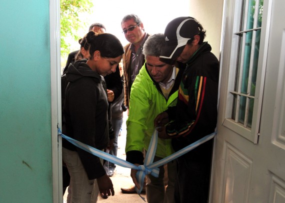 Miriam y Julio recibieron su vivienda. En la foto, dos de sus hijos junto al Gobernador en el desatado de cintas