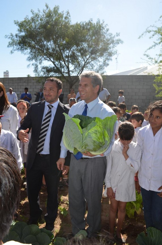 El Gobernador con una planta de lechuga cosechada en la escuela. A su lado, el ministro Sosa.