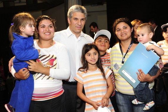 El gobernador junto a una familia, que recibió su casa.