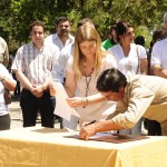 La Ministra de Turismo firma el contrato junto a un trabajador