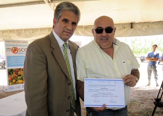 El gobernador, Claudio Poggi, hace entrega del certificado a un de los productores.