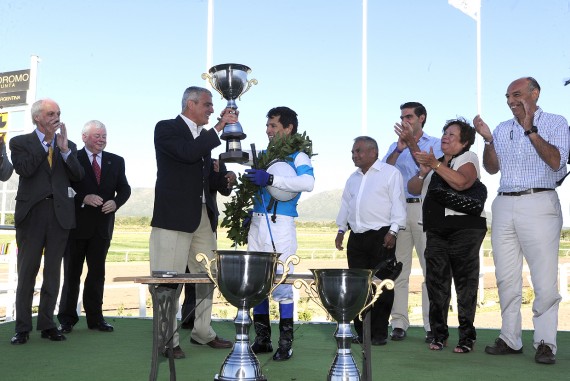 Díaz entrega el trofeo al ganador.