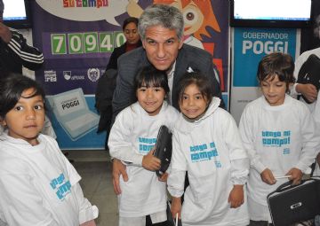 El gobernador Poggi con alumnos que recibieron su computadoras.