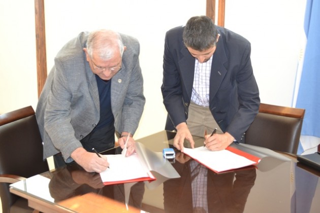 Los funcionarios firmando el convenio de cooperación.
