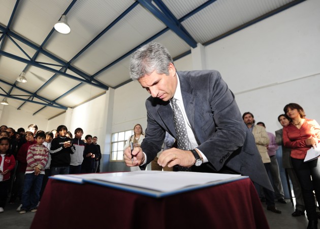 El gobernador firmando el decreto en el Centro Educativo N° 28 “René Favaloro”.