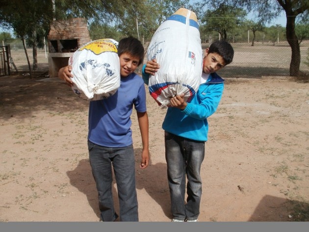 Dos alumnos cargan su valiosa cosecha