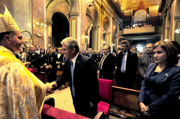 Monseñor Martínez se acerca al primer mandatario Claudio Poggi para estrecharle la mano