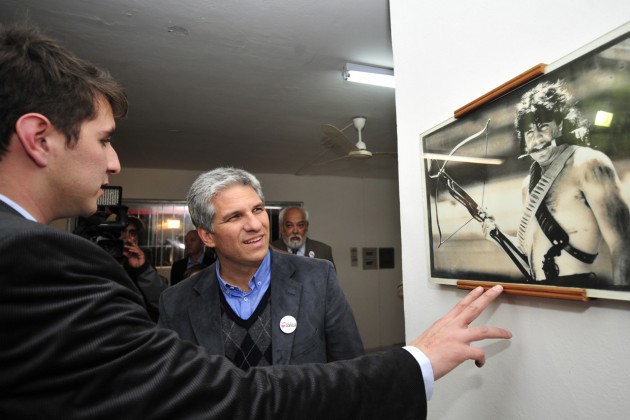 El Gobernador junto al hijo del Bufalo observan una foto 