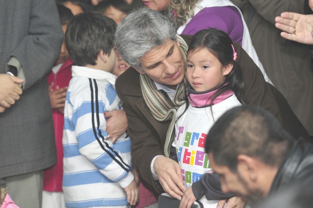 Una de las pequeñas recibe su netbook de manos del Gobernador