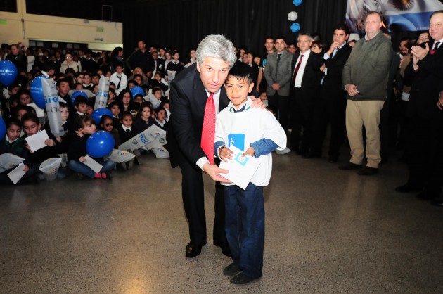 Poggi junto a uno de los chicos que recibió su estampilla escolar.