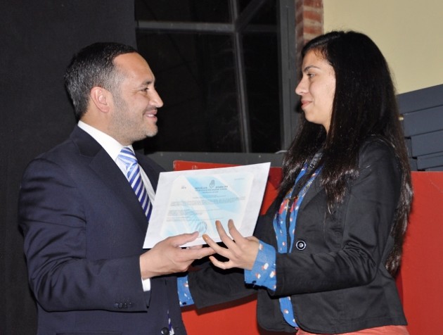 Una egresada recibiendo su diploma de manos del ministro Sosa.