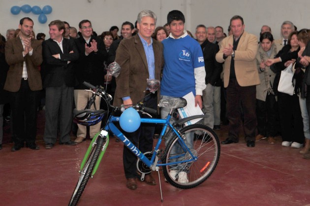 El gobernador junto a un alumno que recibió su bicicleta