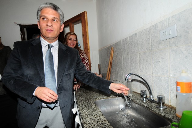 El gobernador Poggi al momento de la llegada del agua caliente en los domicilios. 