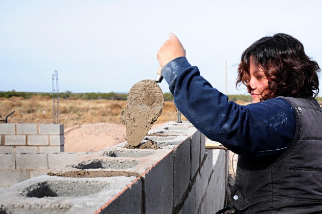 Una  madre trabaja en la construcción de su futuro hogar