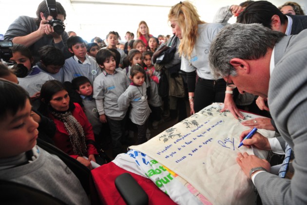 El gobernador firma bandera hecha por chicos de distintas escuelas