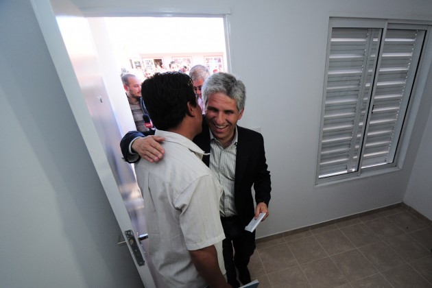 Uno de los propietarios orgulloso abre la puerta de su hogar para el Gobernador
