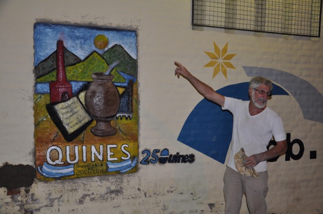 El artista junto al mural que plamó en conmemoración de la fundación de la localidad