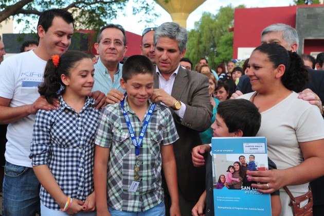 Una familia adjudicataria junto al gobernador Claudio Poggi