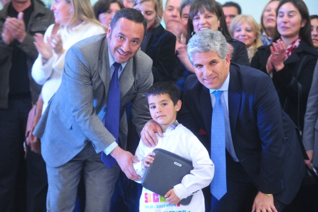 El gobernador y el ministro de Educación  entregando una computadora